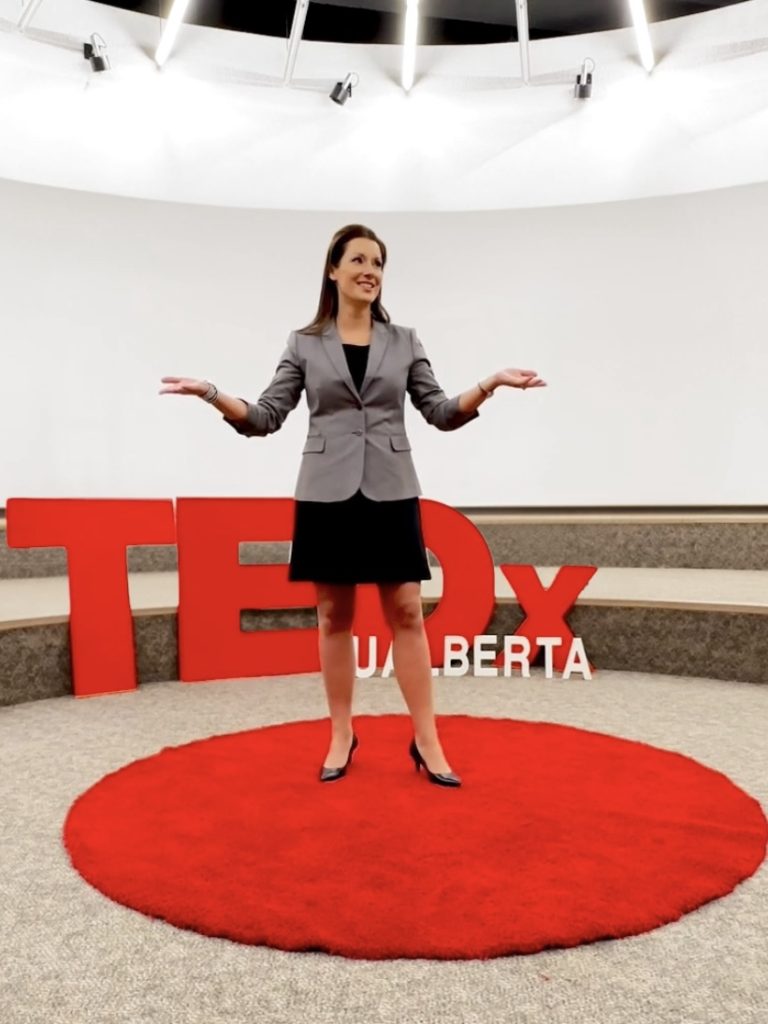 Trisha Fuller speaking on stage at TEDx Alberta about hypnosis therapy, exploring how hypnotherapy helps people create lasting change and personal transformation.